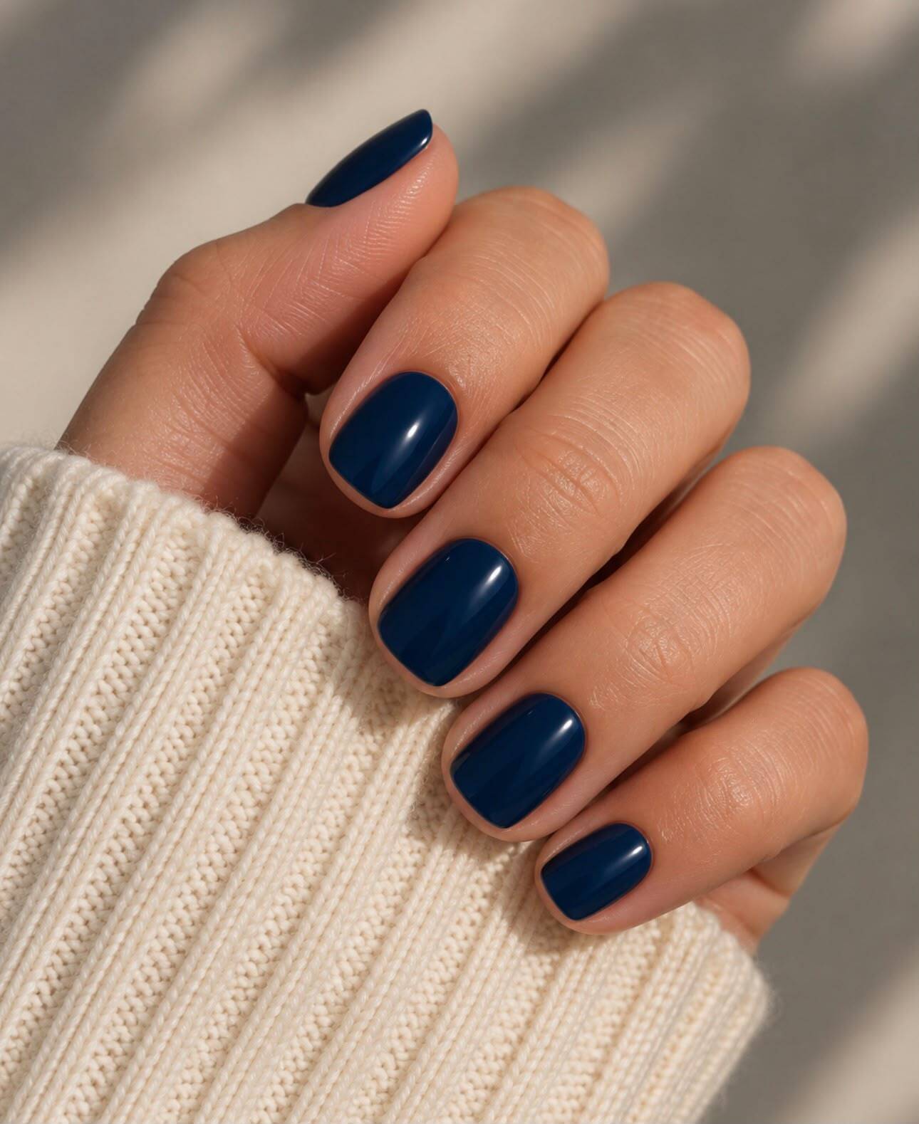 Hand wearing glossy navy square press-on nails